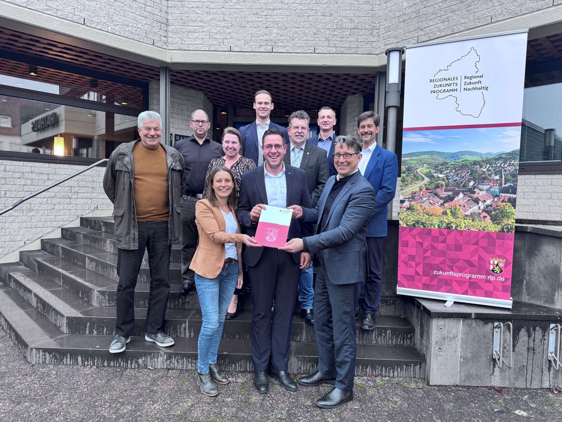 Bürgermeister Marcus Konrad nimmt den RZN-Förderbescheid von Klimaschutzstaatssekretär Hauer im Beisein von den Beigeordneten und Vertretern der Verwaltung entgegen (Foto: MKUEM – Ministerium für Klimaschutz, Umwelt, Energie und Mobilität)